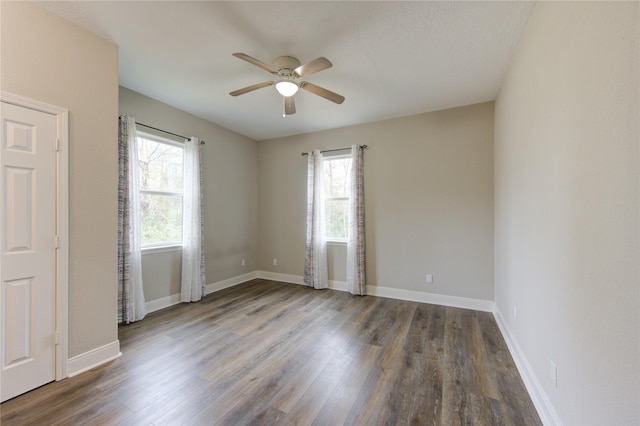 unfurnished room featuring dark hardwood / wood-style flooring, ceiling fan, and a healthy amount of sunlight