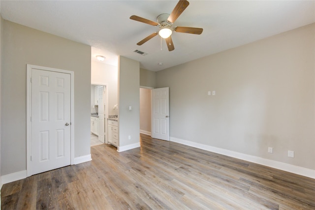 unfurnished bedroom with connected bathroom, light hardwood / wood-style flooring, and ceiling fan