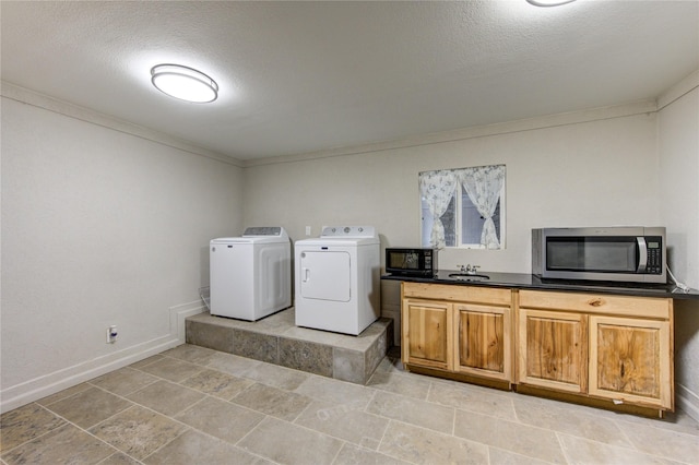 washroom with crown molding, sink, a textured ceiling, and washer and clothes dryer