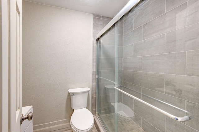 bathroom with toilet and an enclosed shower