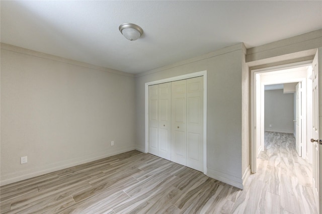 unfurnished bedroom with light wood-type flooring and a closet