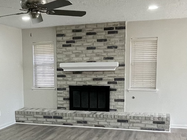 room details featuring hardwood / wood-style flooring, ceiling fan, and a brick fireplace