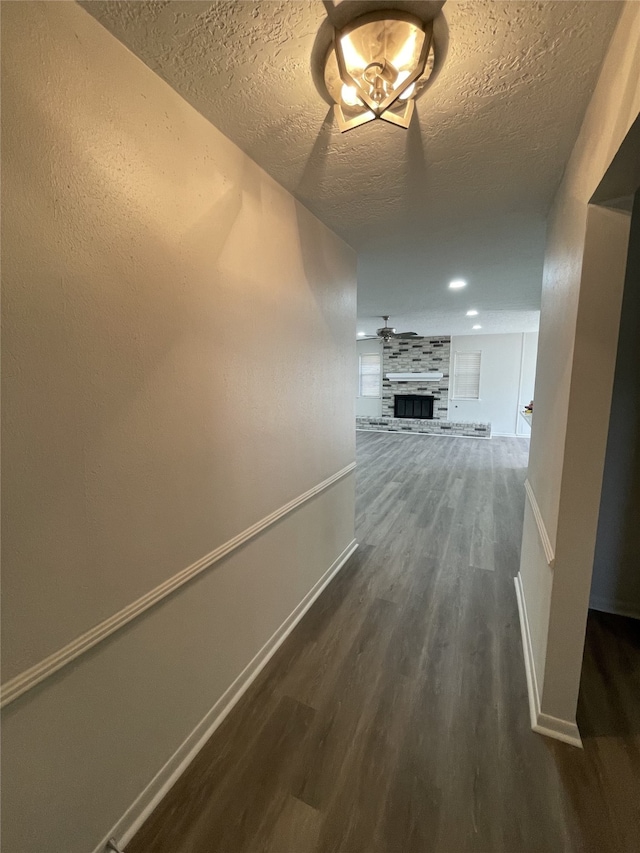 hallway featuring dark hardwood / wood-style floors and a textured ceiling