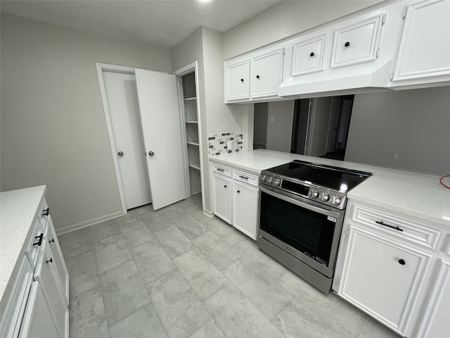 kitchen with decorative backsplash, white cabinets, and stainless steel electric range