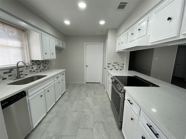 kitchen featuring stainless steel appliances, sink, white cabinets, and backsplash