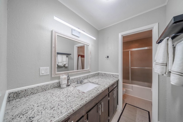 full bathroom with bath / shower combo with glass door, vanity, and toilet