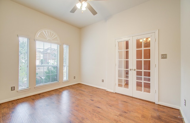 empty room with french doors, ceiling fan, and light wood-type flooring