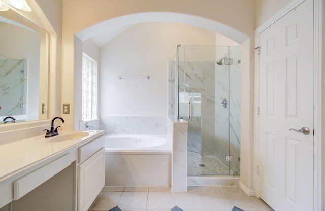 bathroom with vanity, vaulted ceiling, tile patterned floors, and plus walk in shower