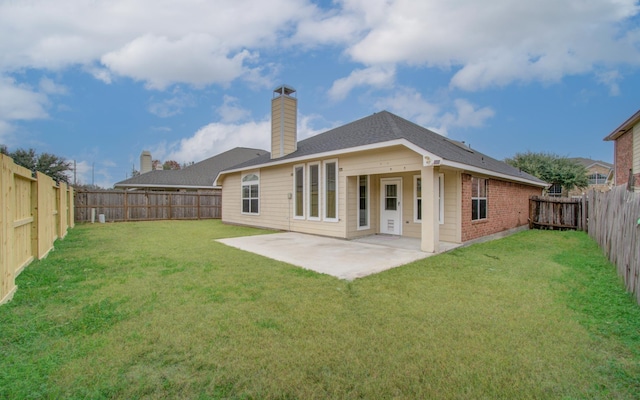 rear view of house featuring a yard and a patio area