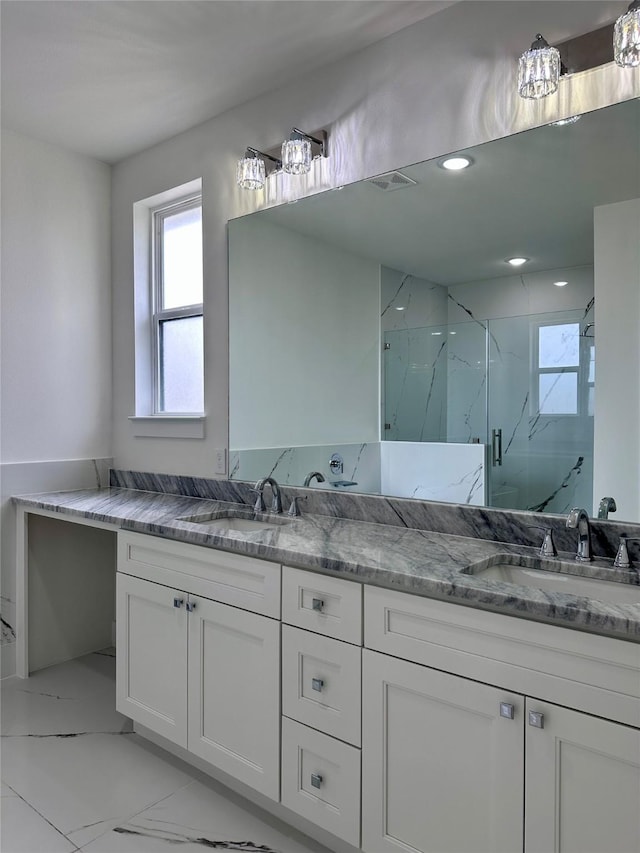 bathroom with vanity and a shower with door