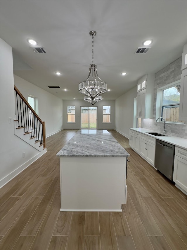 kitchen featuring stainless steel dishwasher, white cabinets, and a kitchen island