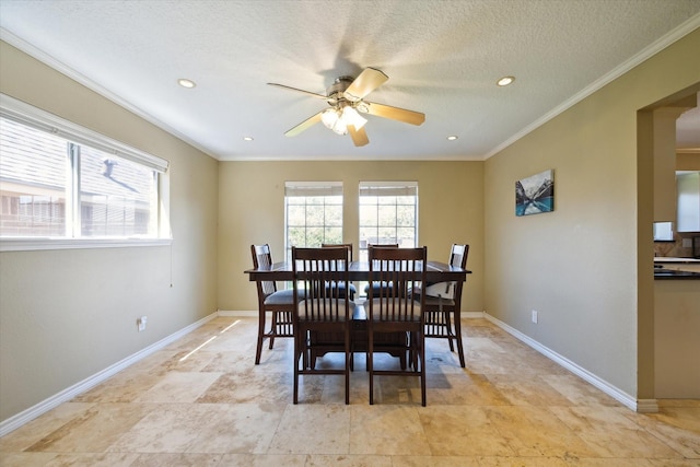 dining space featuring crown molding, ceiling fan, a textured ceiling, and a wealth of natural light