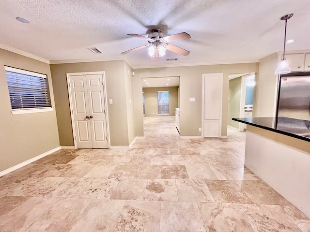 empty room featuring ornamental molding, ceiling fan, and a textured ceiling