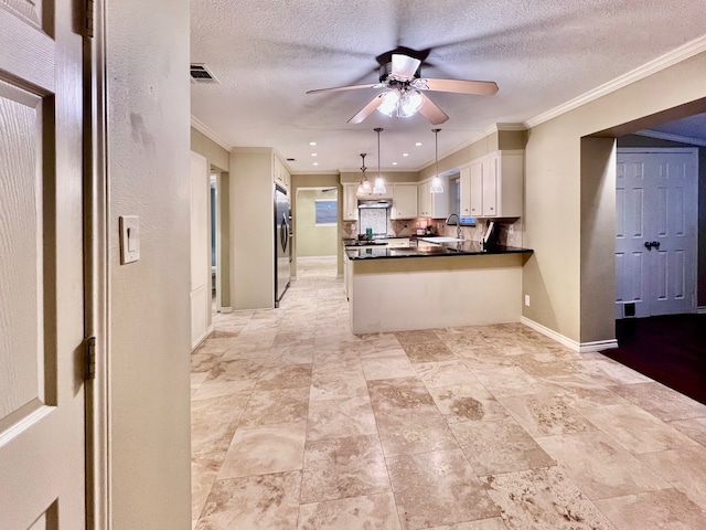 kitchen with pendant lighting, white cabinetry, stainless steel fridge, ornamental molding, and ceiling fan