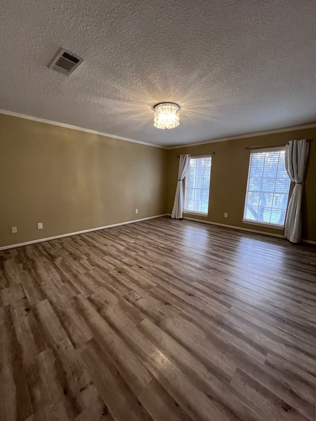 unfurnished room with hardwood / wood-style flooring, ornamental molding, and a textured ceiling