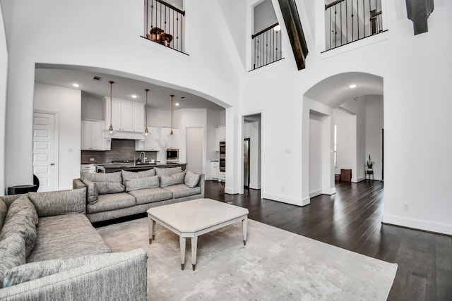 living room featuring a high ceiling and dark hardwood / wood-style floors