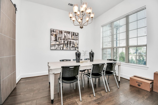 dining space with an inviting chandelier, dark hardwood / wood-style floors, and a barn door