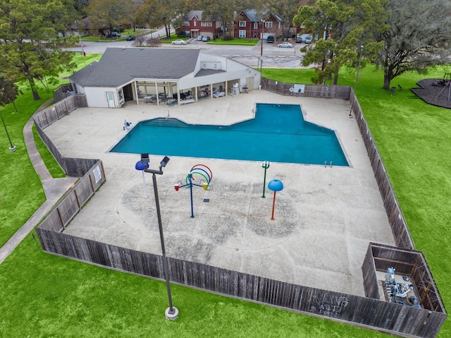 community pool with a patio area, a fenced backyard, and a yard