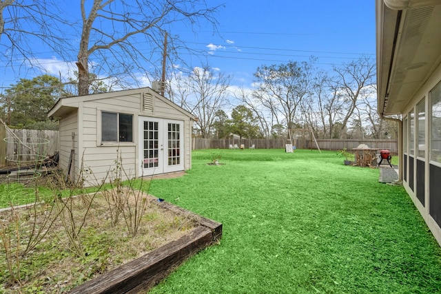 view of yard featuring an outbuilding and french doors