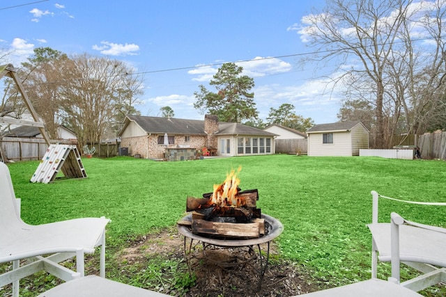 view of yard with an outbuilding, central AC unit, and a fire pit