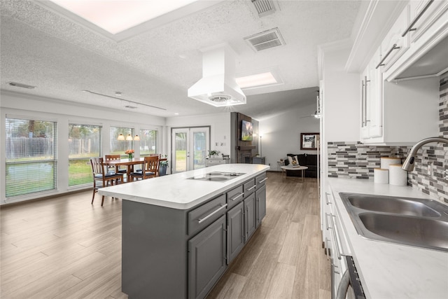 kitchen featuring visible vents, white cabinets, electric cooktop, gray cabinetry, and a sink