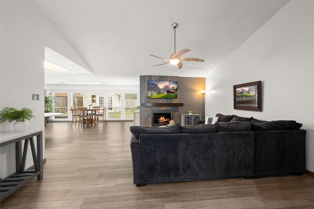 living room featuring vaulted ceiling, ceiling fan, and light hardwood / wood-style floors