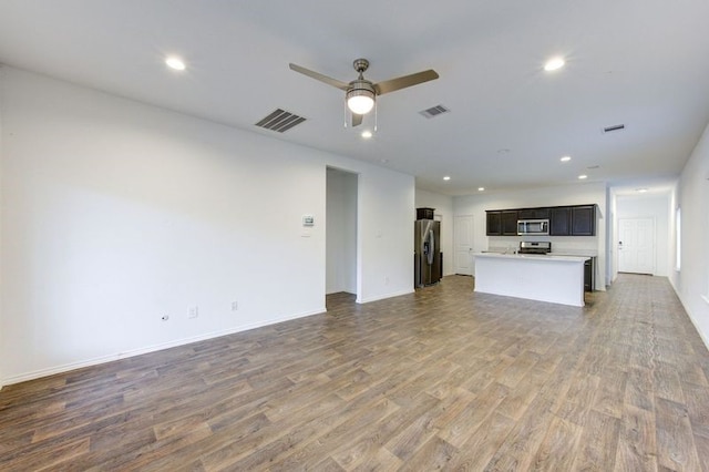 unfurnished living room featuring wood-type flooring and ceiling fan