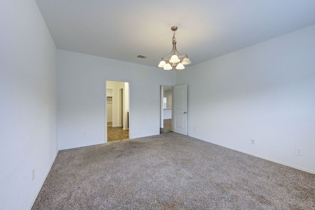 unfurnished bedroom with carpet flooring and a notable chandelier