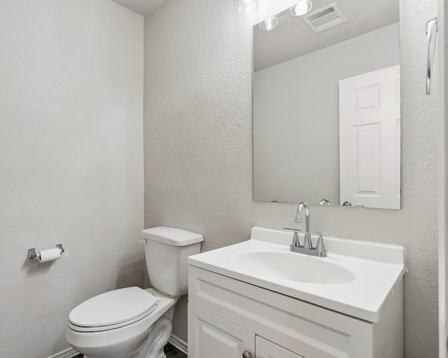 bathroom featuring toilet and vanity