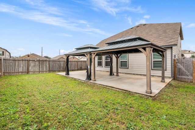 rear view of house featuring a patio, a gazebo, and a lawn