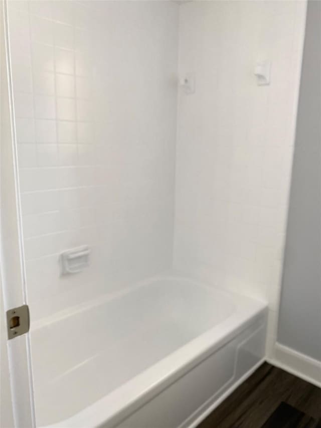 bathroom featuring wood-type flooring and  shower combination