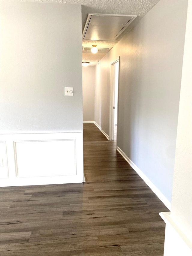 hallway featuring dark hardwood / wood-style floors and a textured ceiling