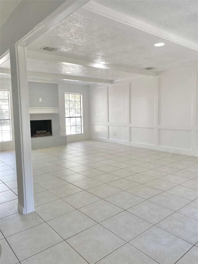 unfurnished living room featuring light tile patterned floors, a fireplace, and a textured ceiling