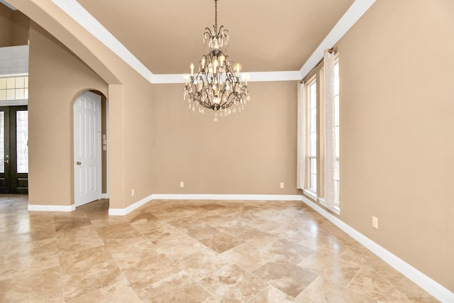 empty room with ornamental molding, a chandelier, and french doors