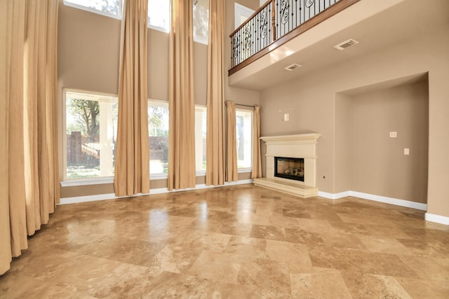 unfurnished living room featuring a towering ceiling