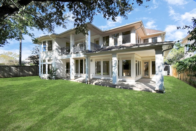 back of property featuring a balcony, a yard, and a patio area