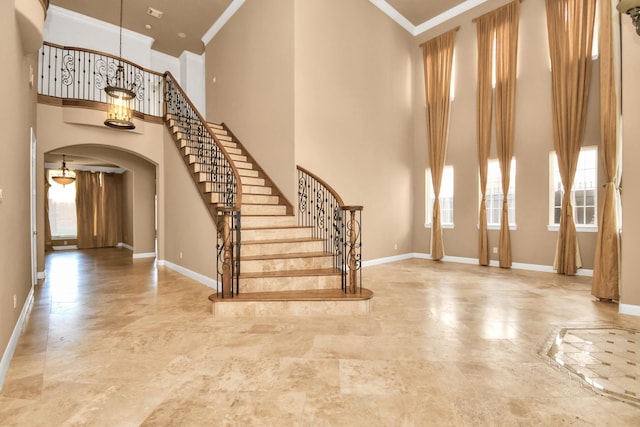 entrance foyer featuring a towering ceiling and ornamental molding