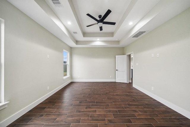 unfurnished room with ceiling fan and a raised ceiling