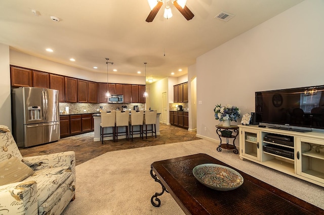 living room featuring ceiling fan and dark colored carpet