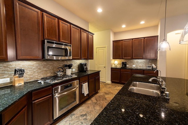 kitchen with dark stone countertops, sink, decorative light fixtures, and stainless steel appliances