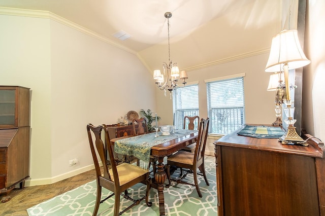 dining room featuring an inviting chandelier, hardwood / wood-style flooring, vaulted ceiling, and ornamental molding