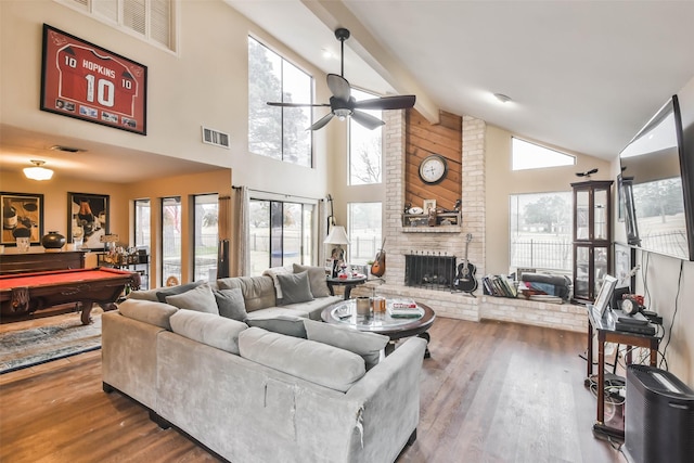 living room featuring beamed ceiling, pool table, a brick fireplace, hardwood / wood-style flooring, and ceiling fan