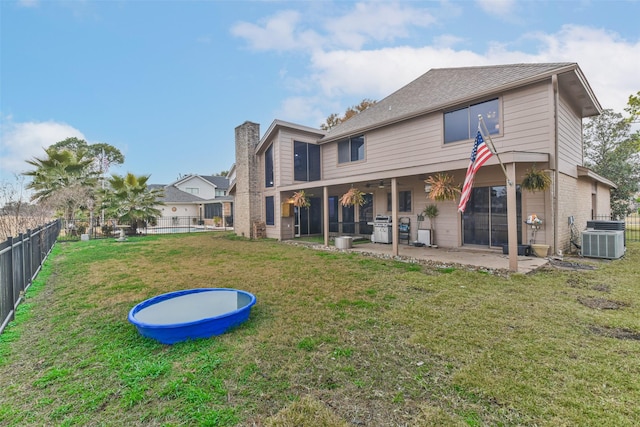 back of house with a patio, a yard, and central AC