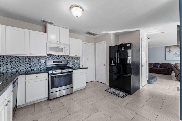 kitchen featuring white cabinetry, decorative backsplash, stainless steel appliances, and dark stone counters