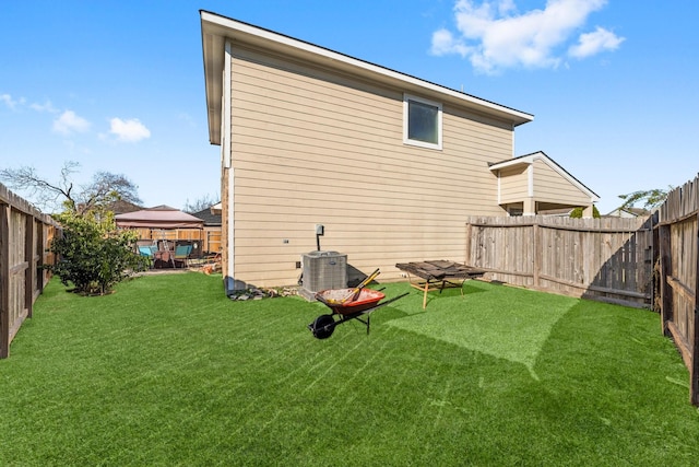 back of property featuring a gazebo, central AC, and a lawn