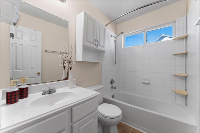 full bathroom featuring vanity, tiled shower / bath combo, tile patterned floors, and toilet