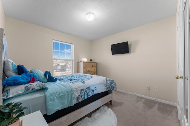 bedroom featuring light colored carpet and a textured ceiling