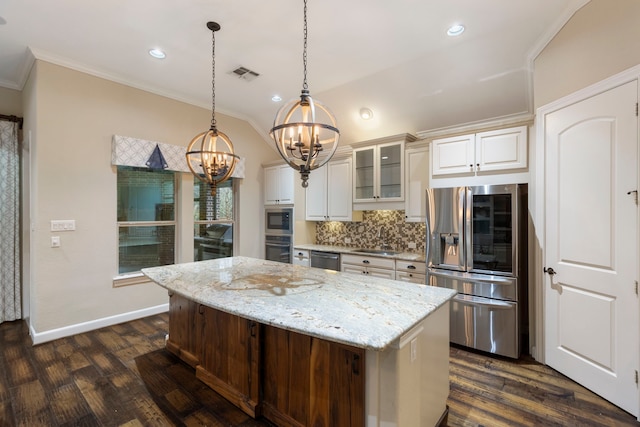 kitchen featuring sink, appliances with stainless steel finishes, a kitchen island, pendant lighting, and light stone countertops