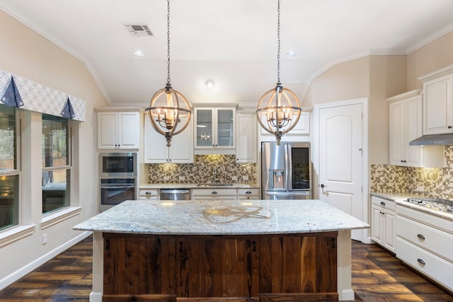 kitchen with a kitchen island, appliances with stainless steel finishes, and pendant lighting