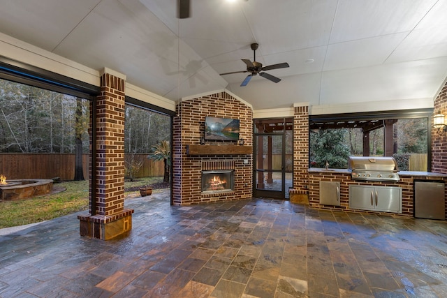 view of patio with an outdoor brick fireplace, area for grilling, an outdoor kitchen, and ceiling fan